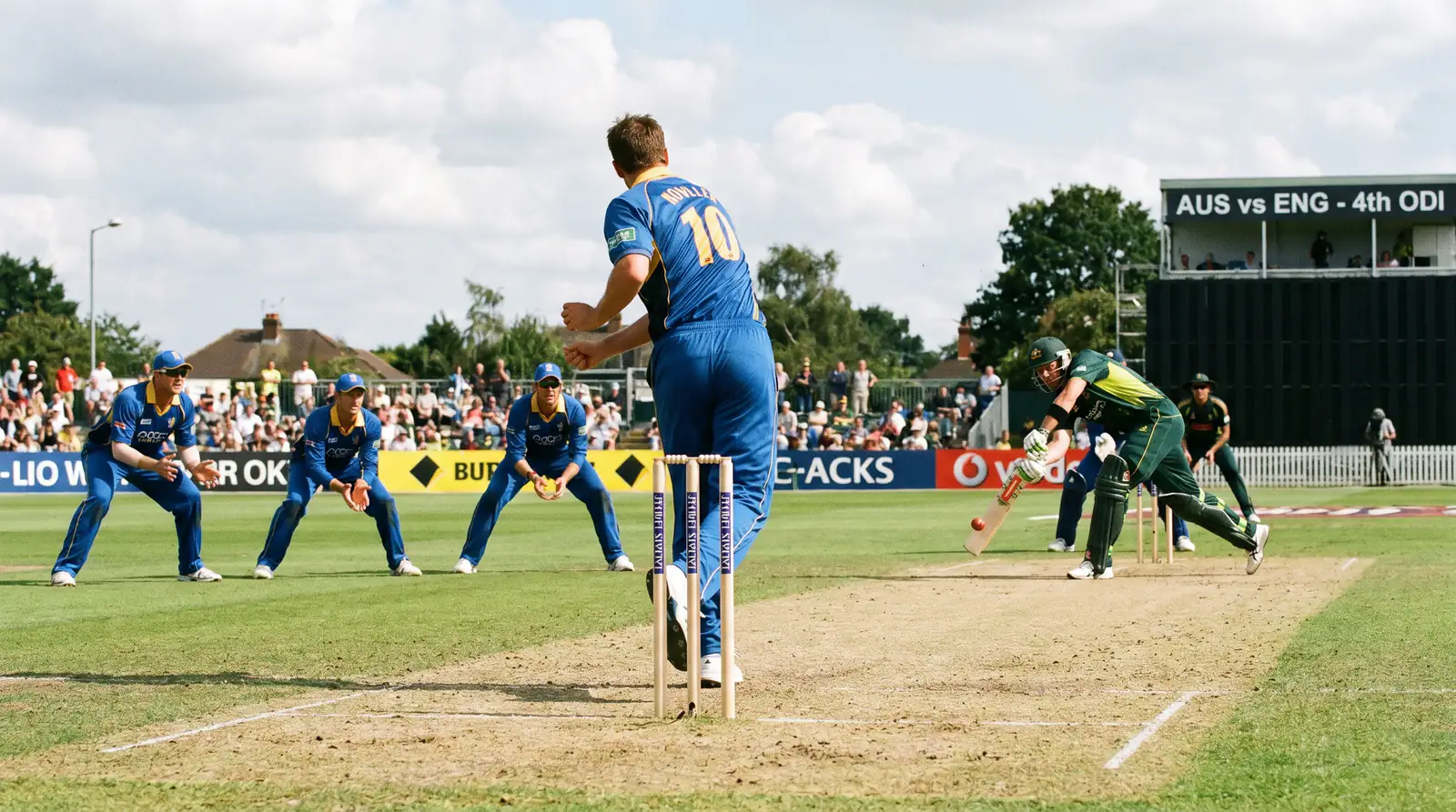 Cricket bowler delivering a tight line with fielders set to prevent boundaries during limited-overs play