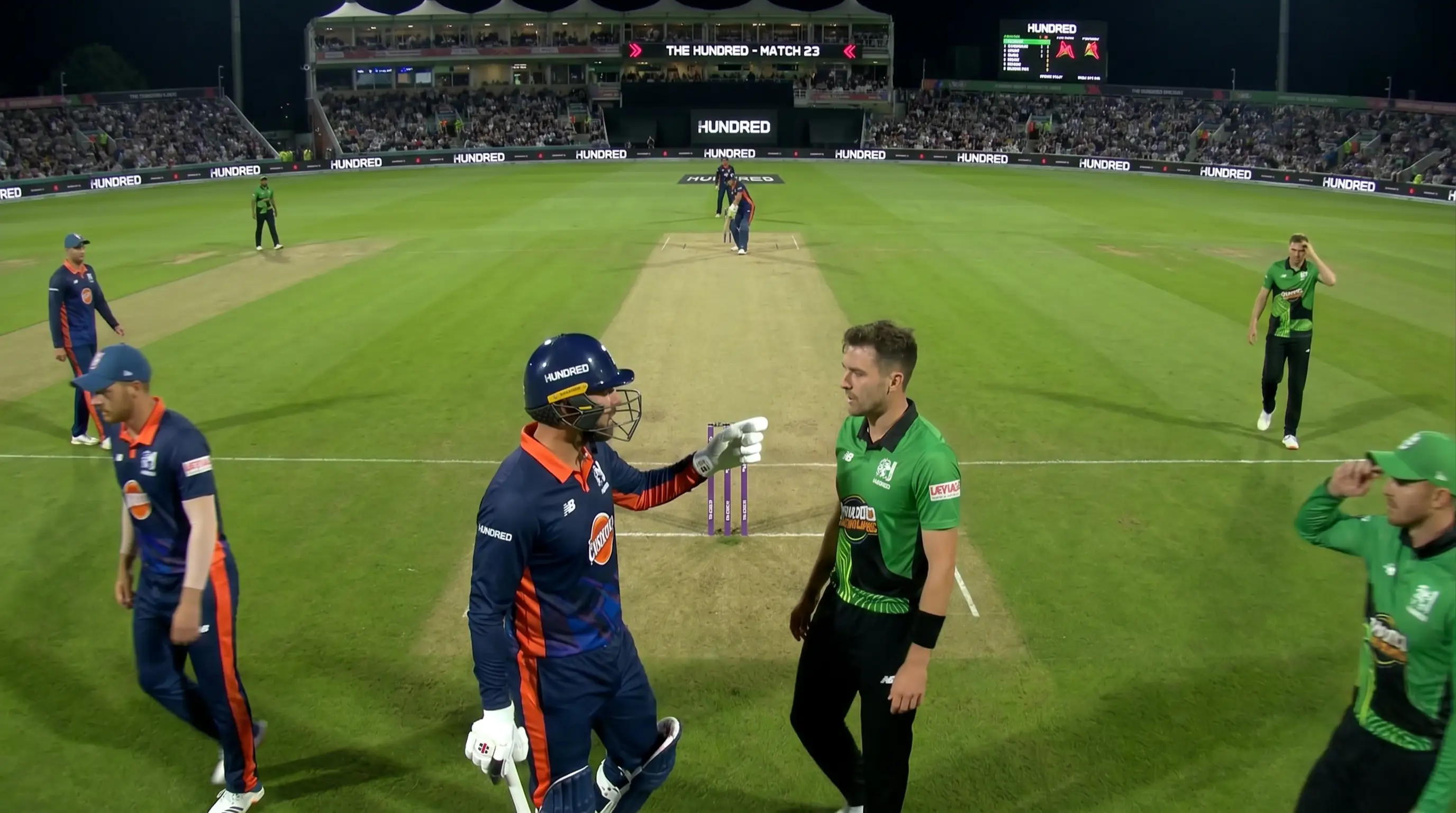 Hundred cricket captain conferring with a bowler mid-over during a tactical bowling change