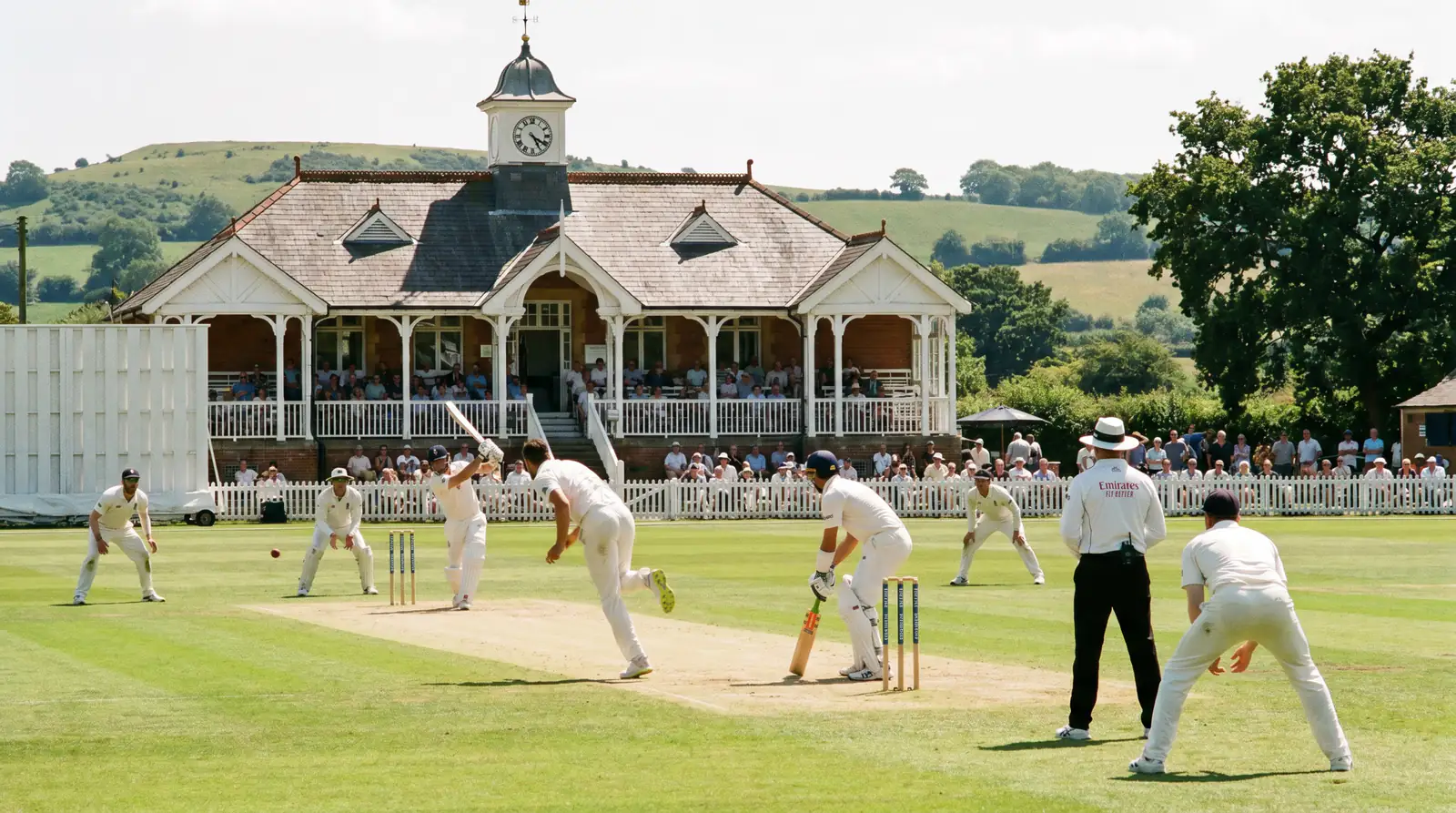 Test cricket match in progress at a traditional English ground on a sunny day