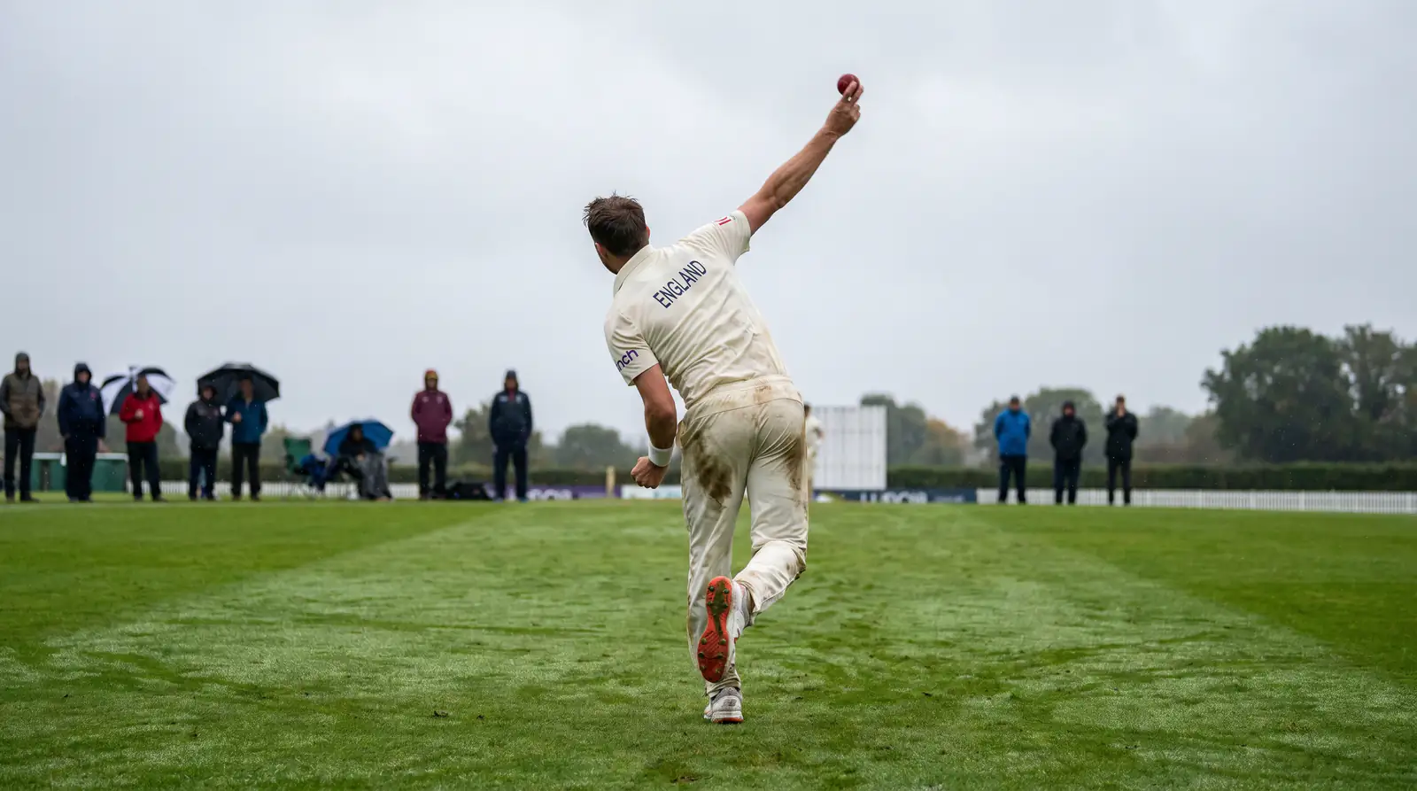 Fast bowler delivering a ball under overcast English skies during a morning Test session